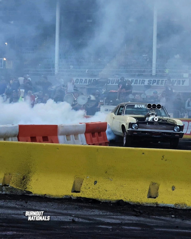 A blown Nova laying down a smoke burnout at a track event